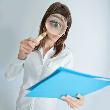 woman with magnifying glass reading documents