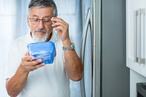 man inspecting container of food