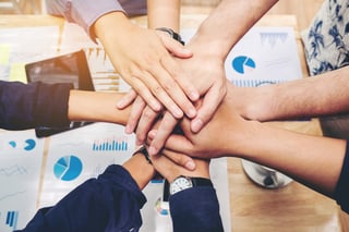 group of people putting with hands in the middle