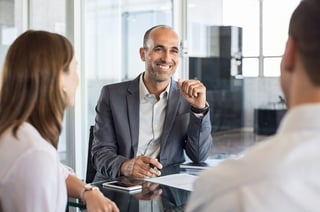 3 people talking at a desk