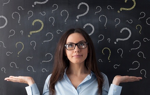 businesswoman_surrounded_by_question_marks_on_blackboard