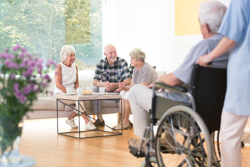 group of senior citizens sitting on sofa in common area