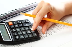 hand_holding_pencil_typing_on_calculator
