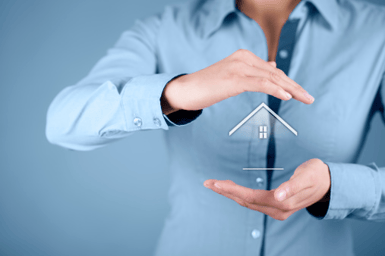 person protecting image of a house with their hands