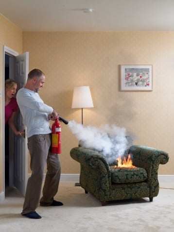 man_extinguishing_fire_on_arm_chair